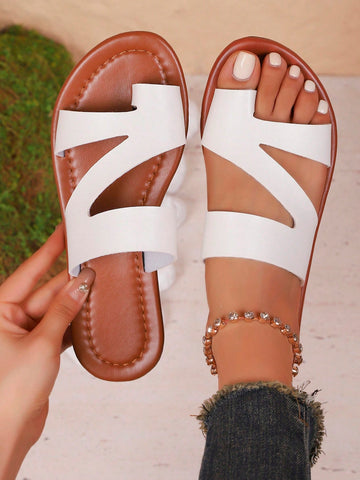 Women’s minimalist flat flip flop sandals with toe post and cut-out detail, lightweight design for beach and vacation wear, in white and brown tones.