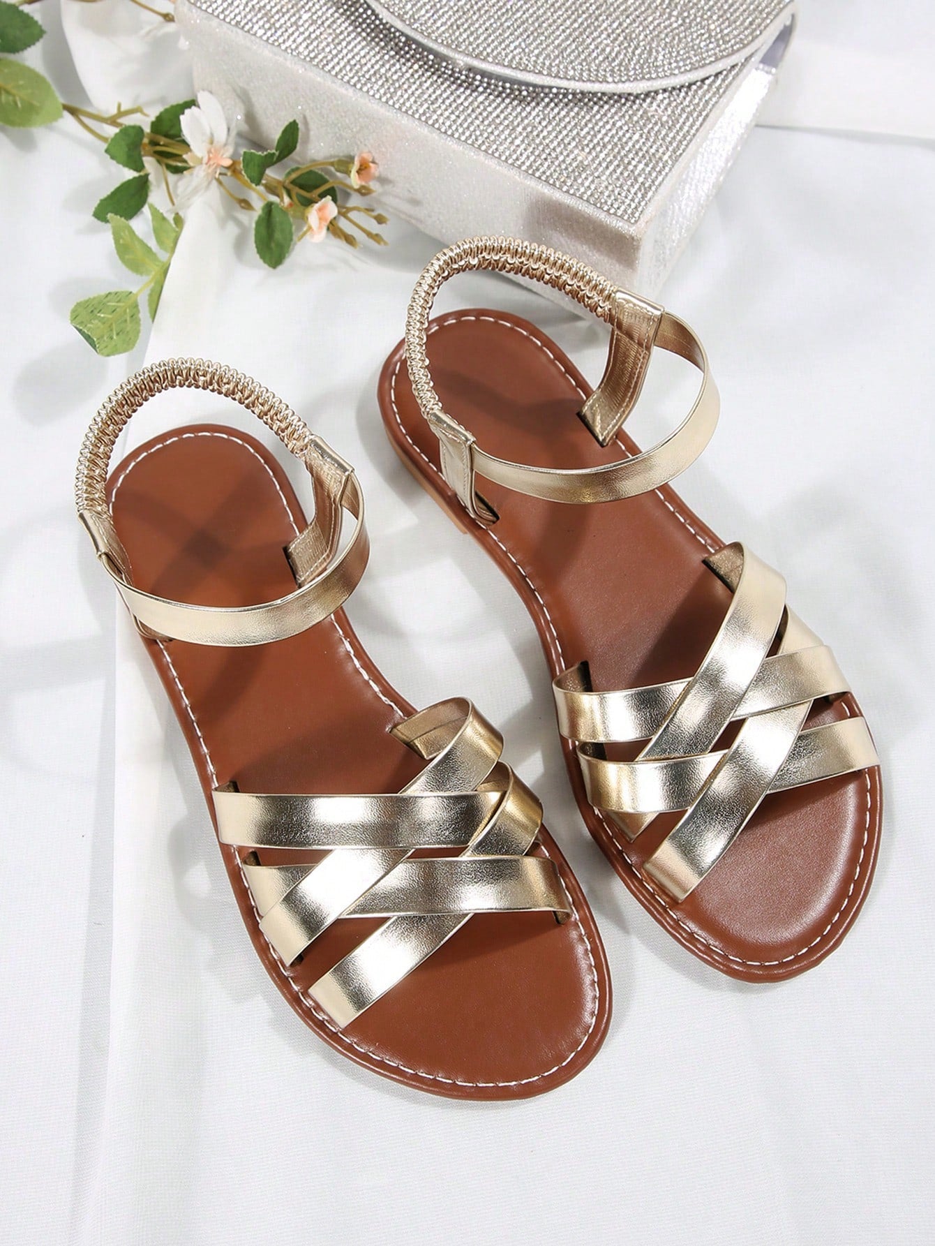 Women’s flat slide sandals with criss-cross straps, open toe, and braid detail, designed for lightweight casual and beach wear.