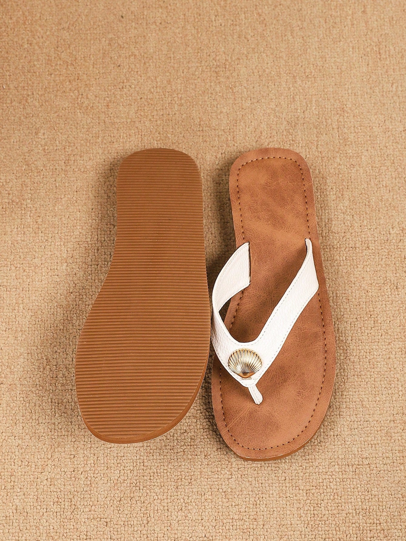 Brown vintage chic flip flops with metal shell decor, toe-post slide design, criss cross straps, and wedge sole for casual beach and outdoor wear.