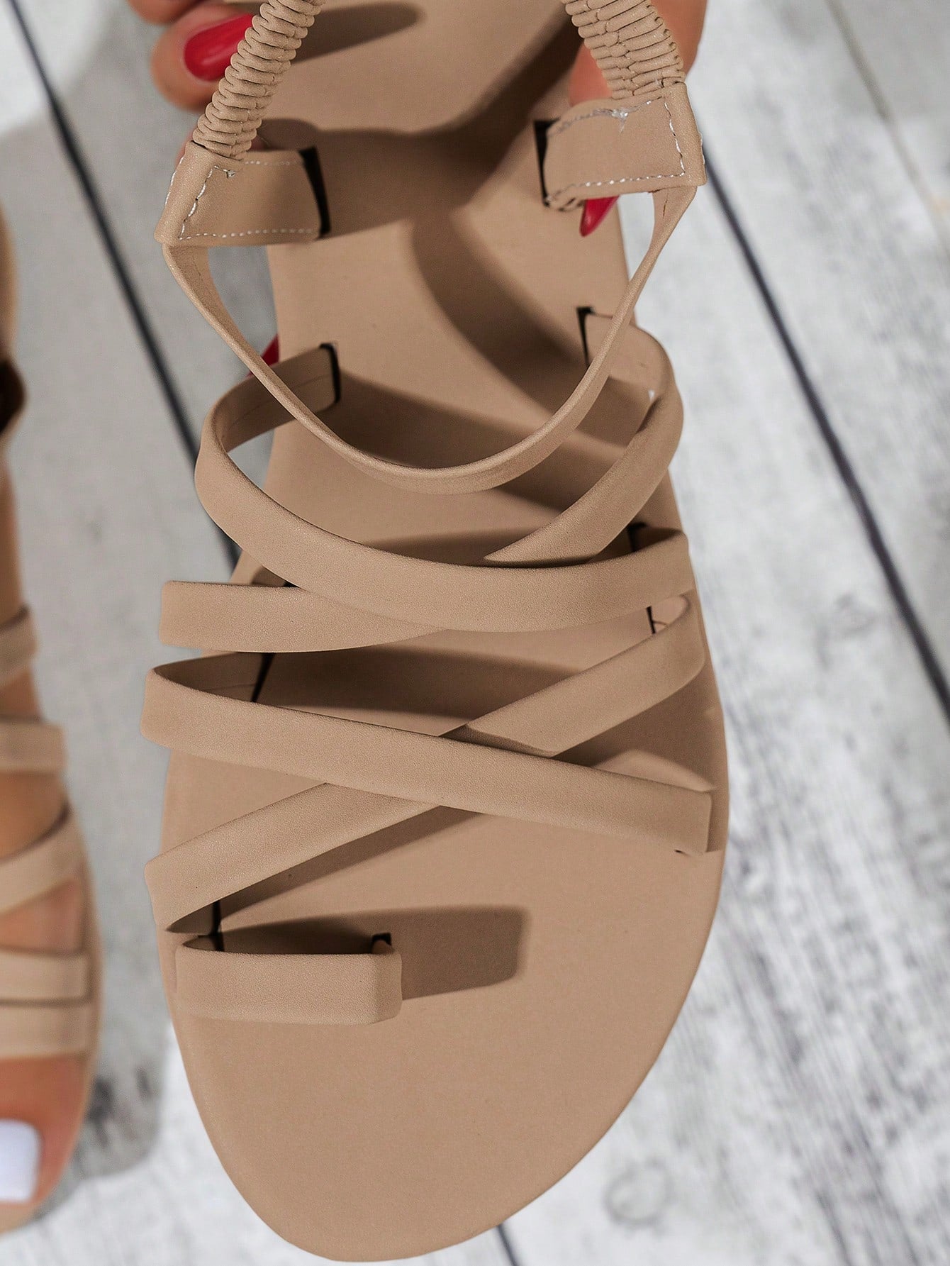 Women's flat sandals featuring a solid-color design with criss-cross braided straps and a toe-post slide style, suitable for beach, vacation, and casual wear.