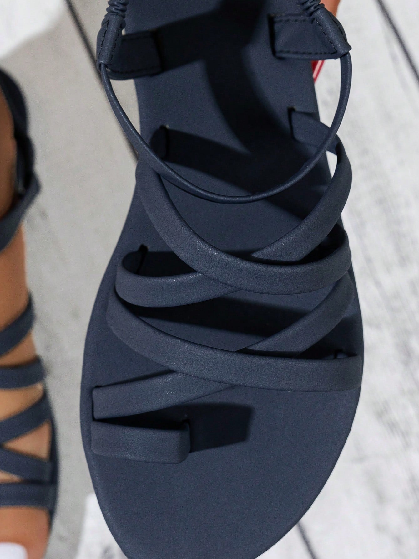 Women's flat sandals featuring a solid-color design with criss-cross braided straps and a toe-post slide style, suitable for beach, vacation, and casual wear.