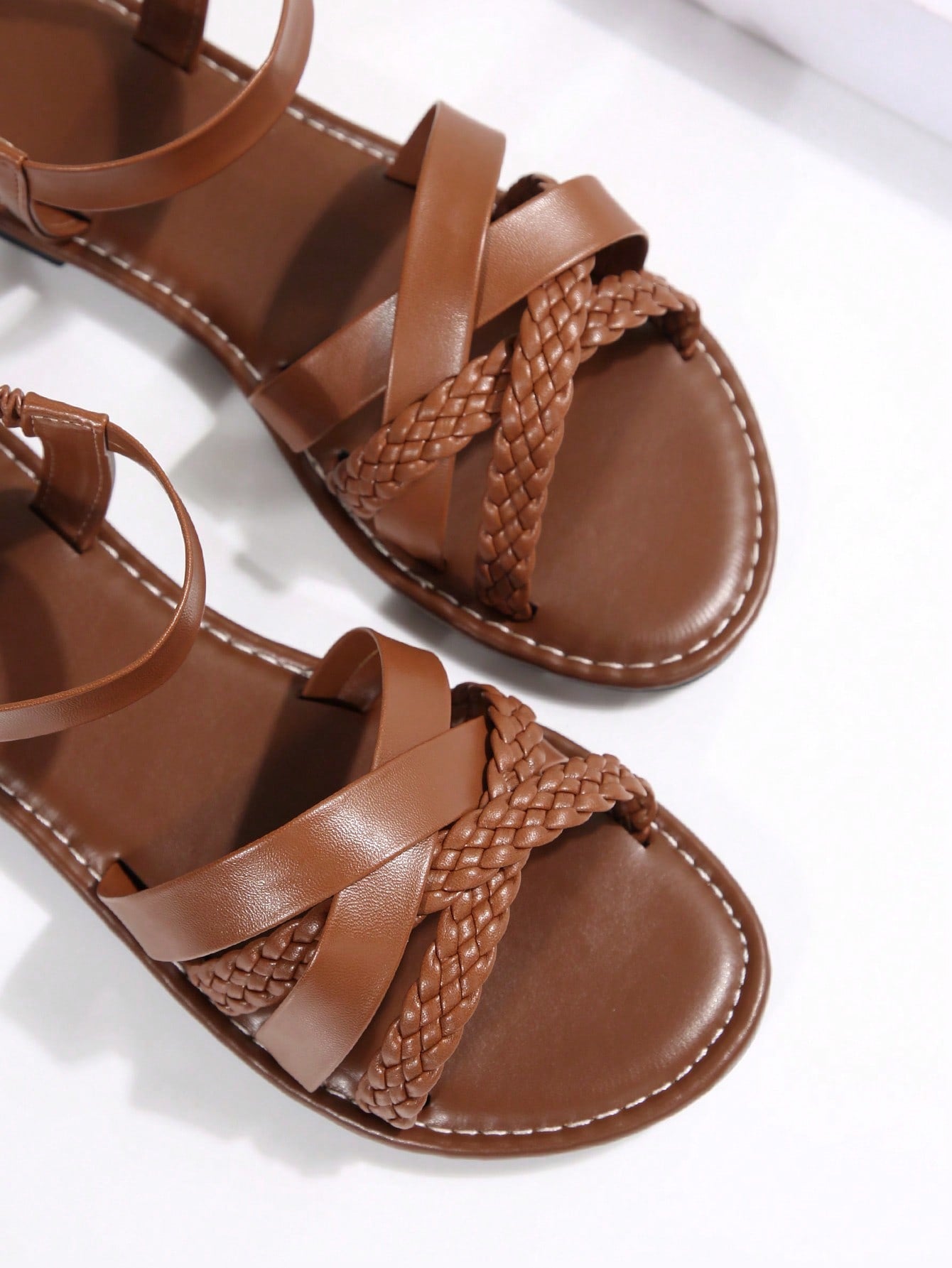 Women’s flat slide sandals with criss-cross straps, open toe, and braid detail, designed for lightweight casual and beach wear.