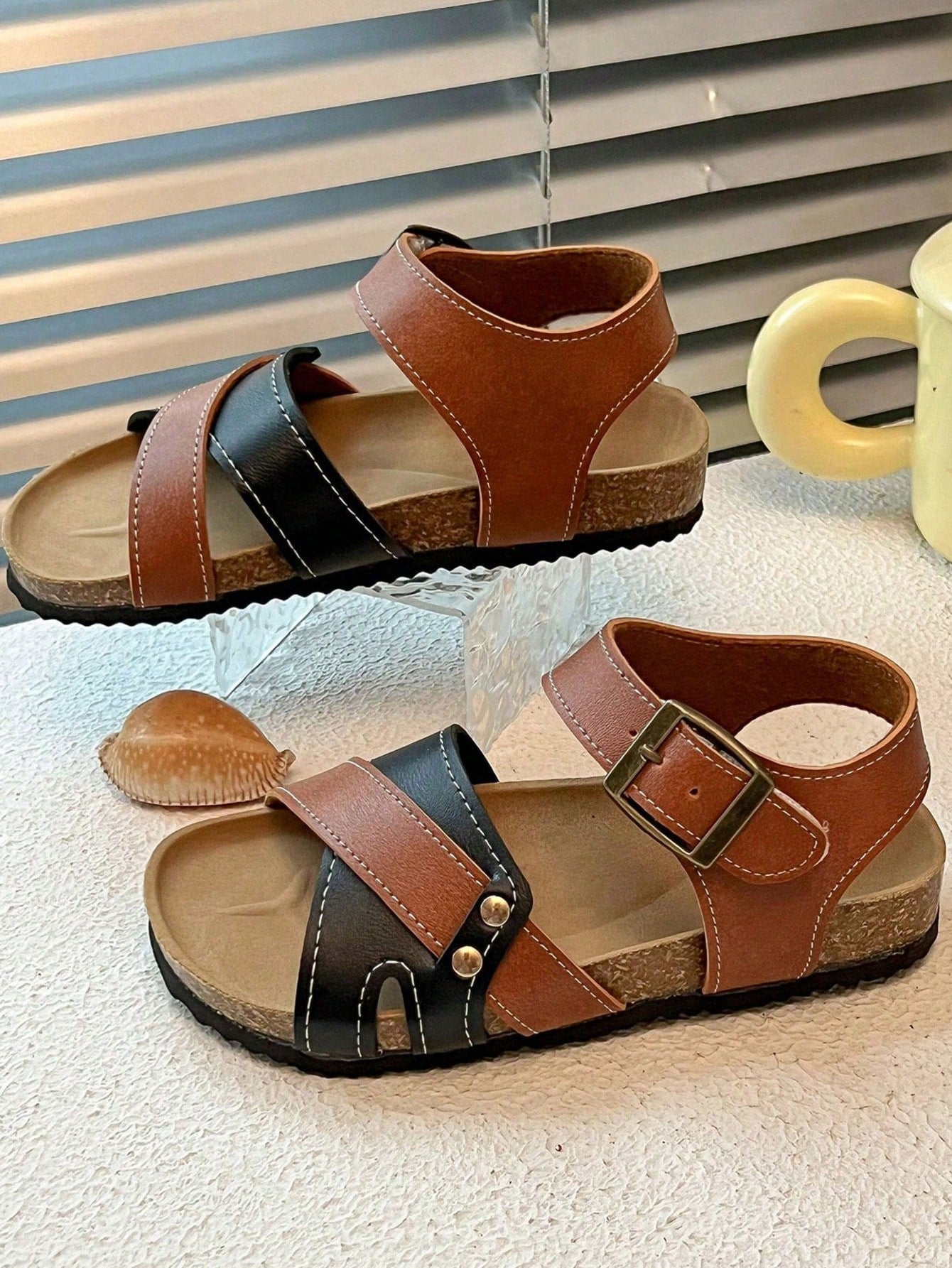 Pair of girls' pink open-toe flat sandals with ankle straps, buckle details, and a non-slip black rubber outsole.