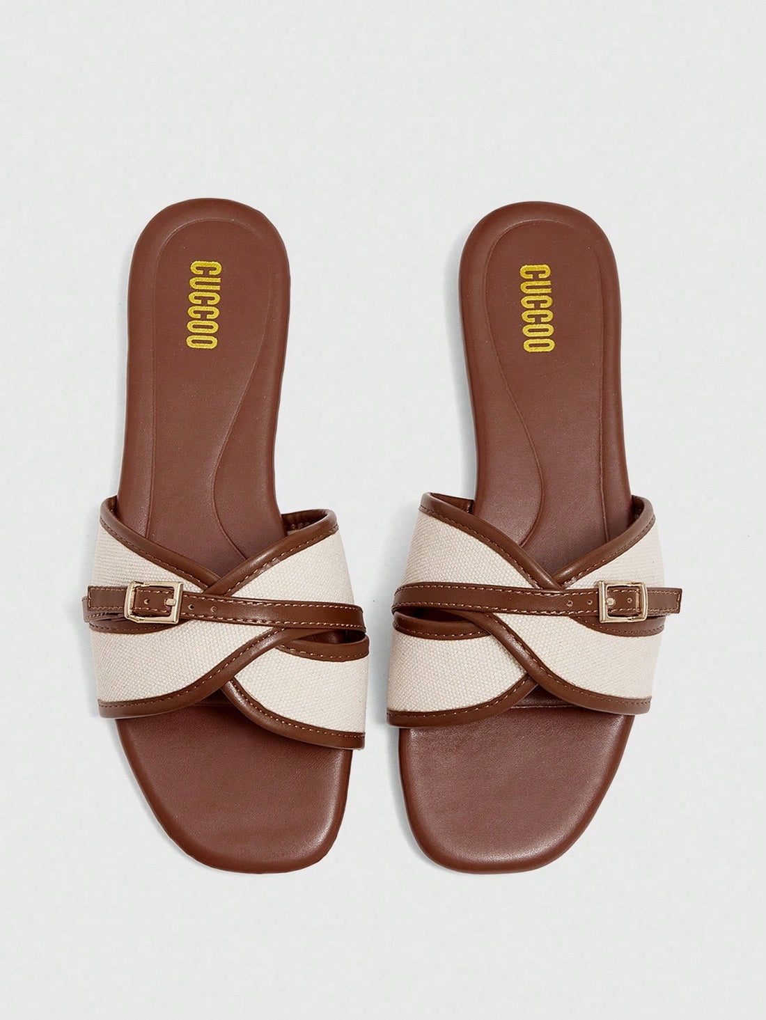 Women's flat slide sandals featuring a simple buckle strap and color block design, in brown tones, with a flat sole for casual vacation and outdoor wear.