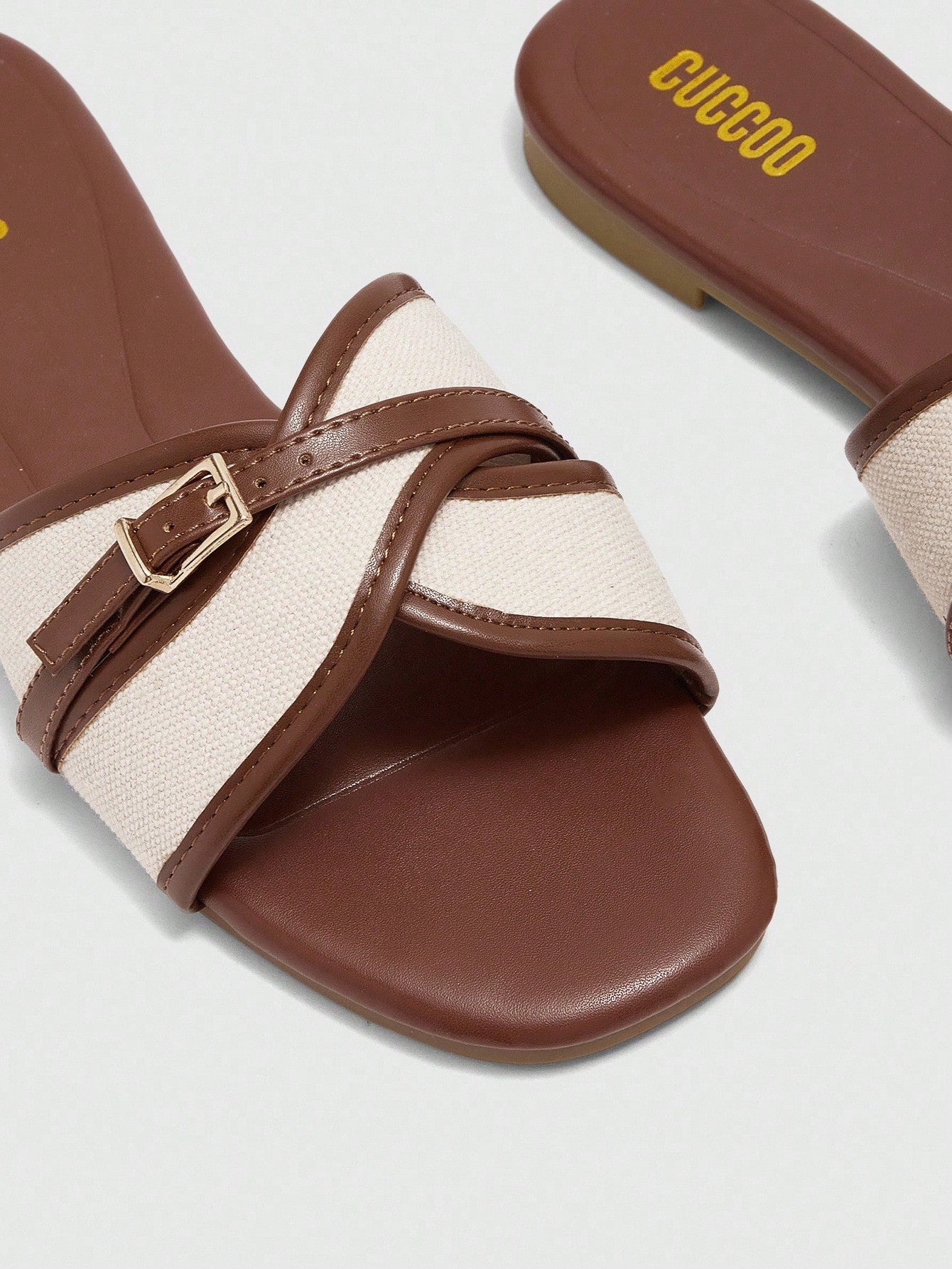 Women's flat slide sandals featuring a simple buckle strap and color block design, in brown tones, with a flat sole for casual vacation and outdoor wear.