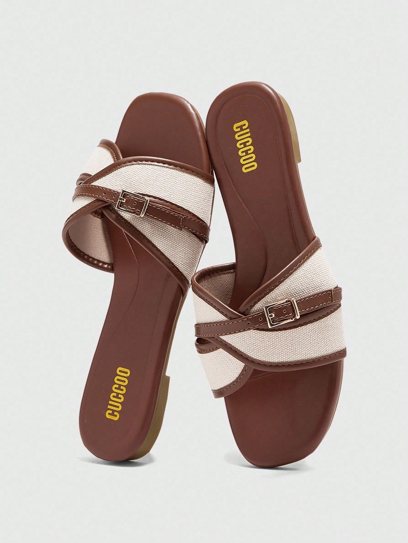Women's flat slide sandals featuring a simple buckle strap and color block design, in brown tones, with a flat sole for casual vacation and outdoor wear.