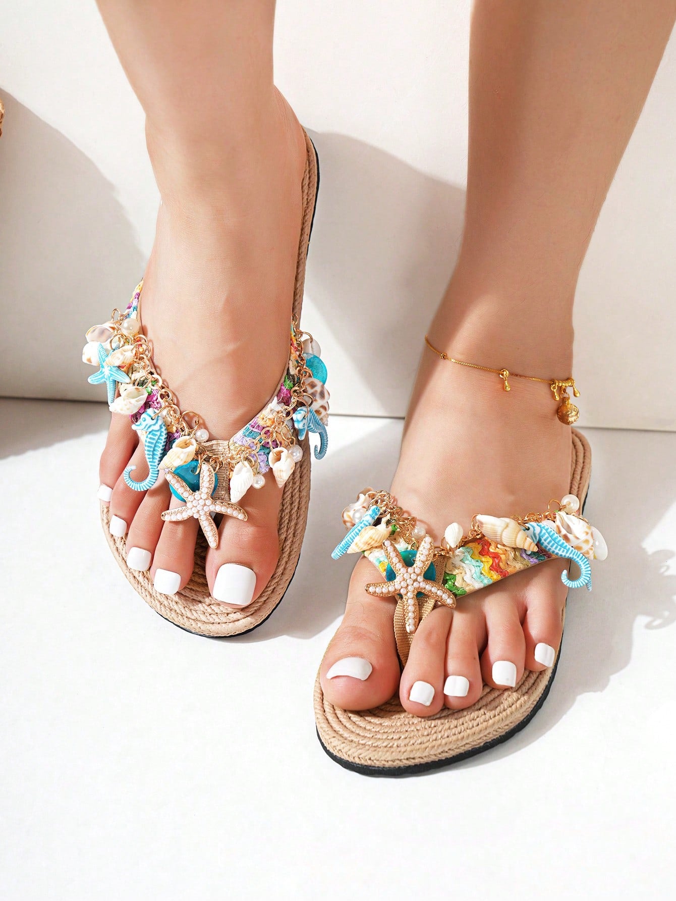 Handmade women’s beach flip flop sandals with shell and starfish rhinestone decorated woven straps, flat thong style, and lightweight non-slip sole.