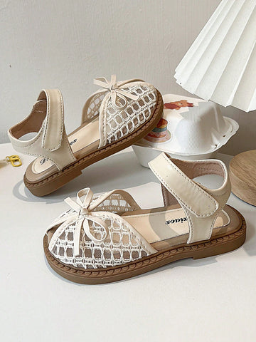 Pair of girls' pink open-toe flat sandals with ankle straps, buckle details, and a non-slip black rubber outsole.