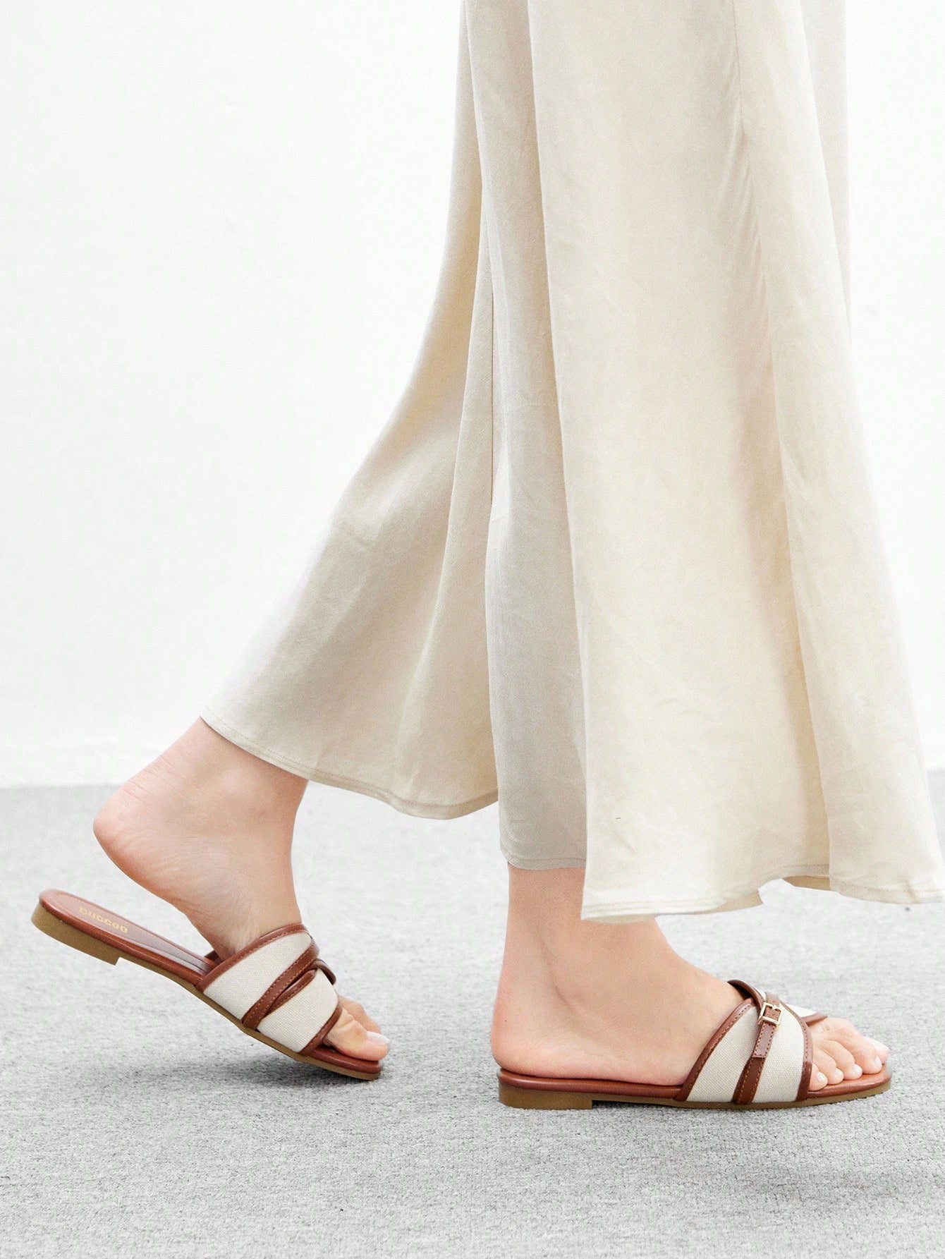 Women's flat slide sandals featuring a simple buckle strap and color block design, in brown tones, with a flat sole for casual vacation and outdoor wear.
