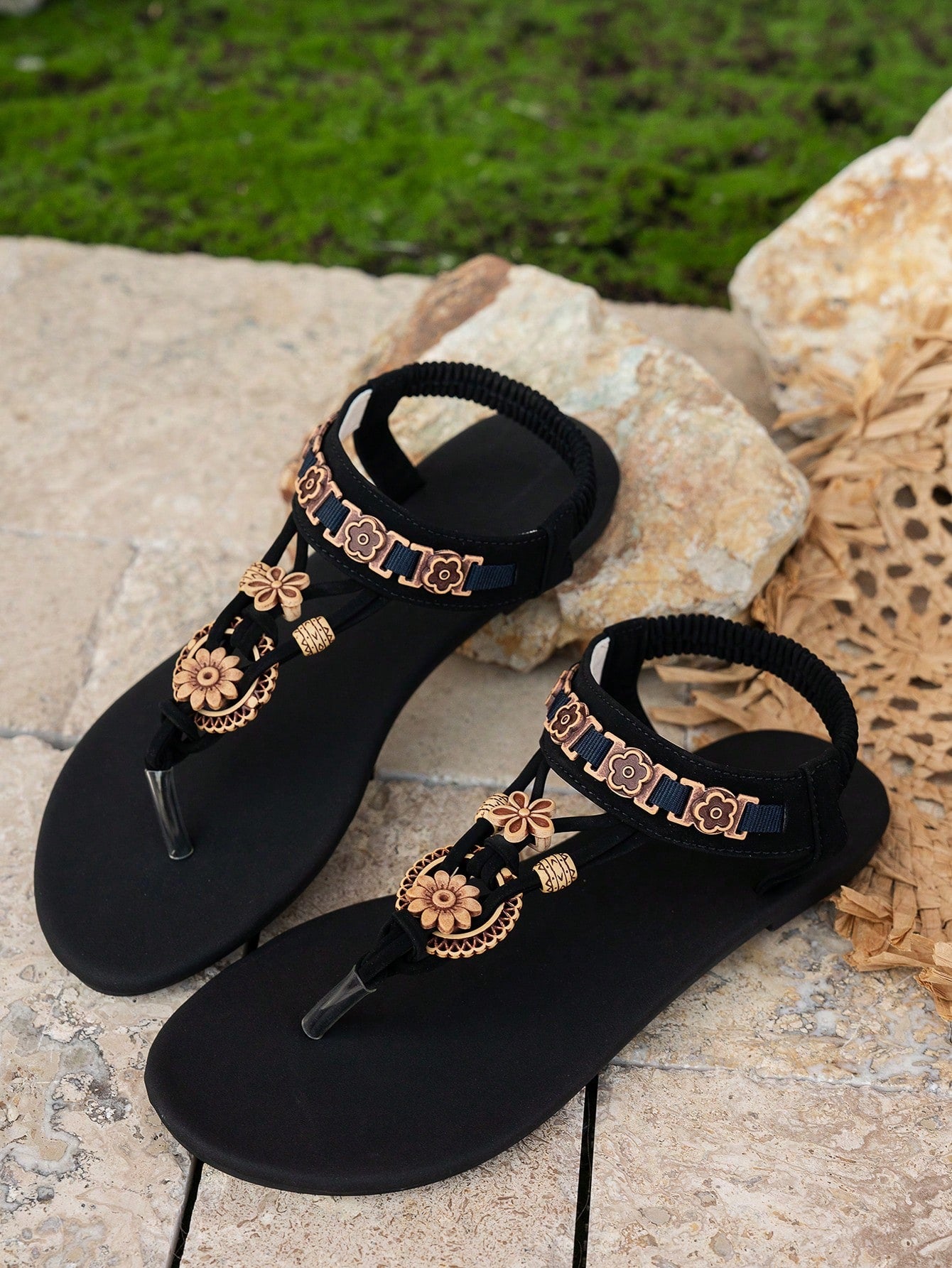 Black women's bohemian thong flat sandals with beaded details, open toe, slip-on design, and rear elastic band, suitable for beach and vacation wear.