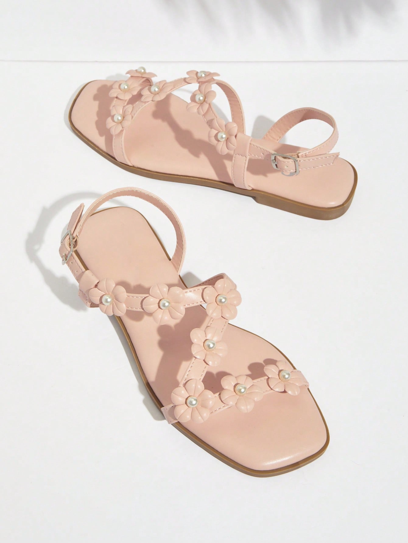 Women's flat open-toe sandals featuring a buckle detail and PU leather construction with a flat sole.