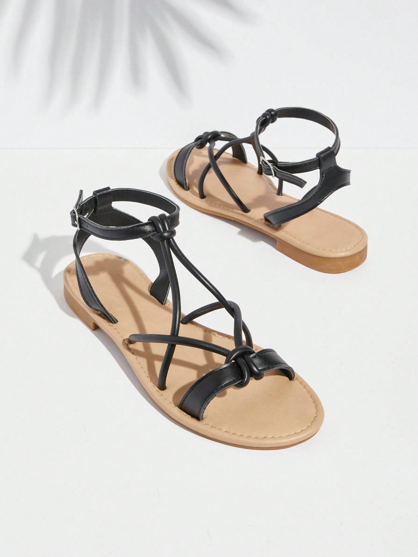 Women's flat open-toe sandals featuring a buckle detail and PU leather construction with a flat sole.