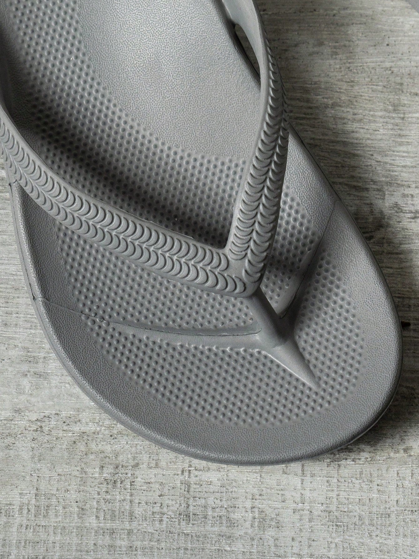 Women's solid color flip flops with open-toe design, flat sole, and cut-out details, suitable for casual indoor or outdoor wear at the beach or pool.