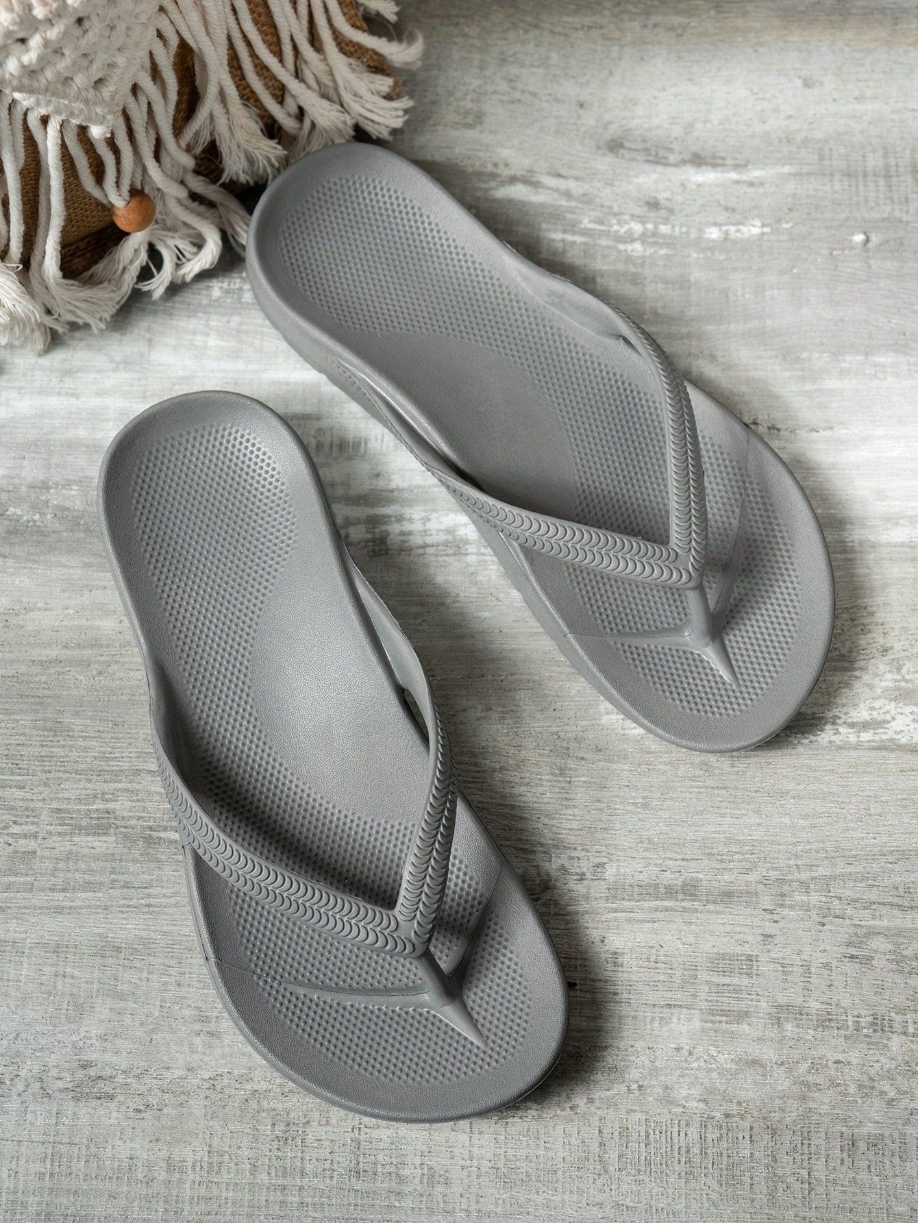 Women's solid color flip flops with open-toe design, flat sole, and cut-out details, suitable for casual indoor or outdoor wear at the beach or pool.