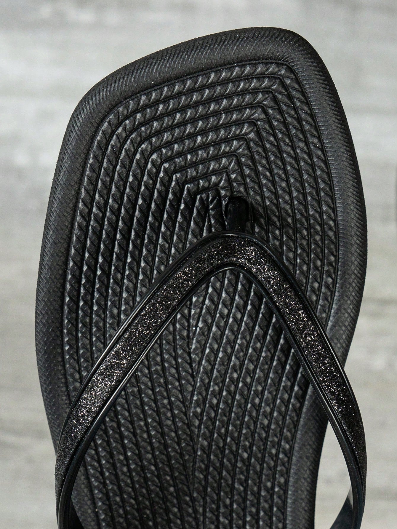 Women's solid color flip flops with open-toe design, flat sole, and cut-out details, suitable for casual indoor or outdoor wear at the beach or pool.