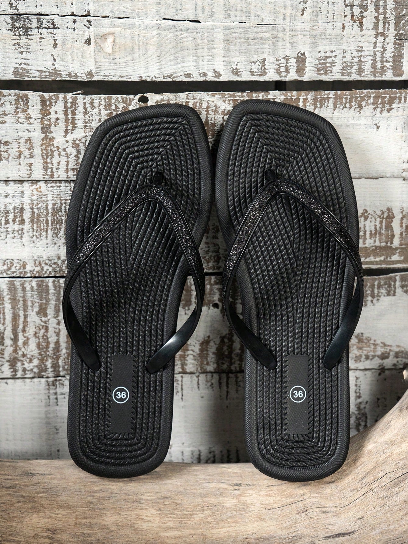 Women's solid color flip flops with open-toe design, flat sole, and cut-out details, suitable for casual indoor or outdoor wear at the beach or pool.