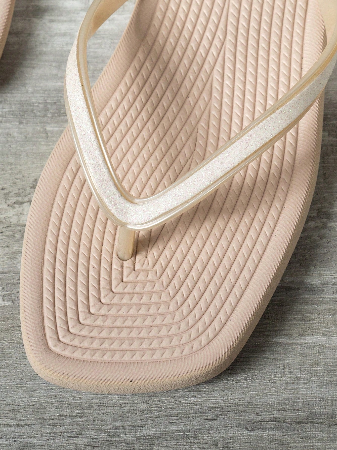 Women's solid color flip flops with open-toe design, flat sole, and cut-out details, suitable for casual indoor or outdoor wear at the beach or pool.