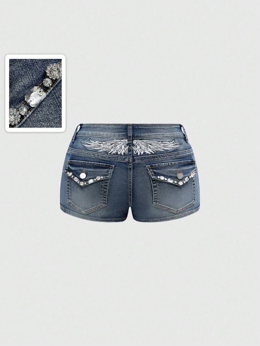 Blue ultra low waist mini shorts with ripped details, zipper fly, button closure, back wing embroidery, and rhinestone decor in a Y2K grunge punk style.