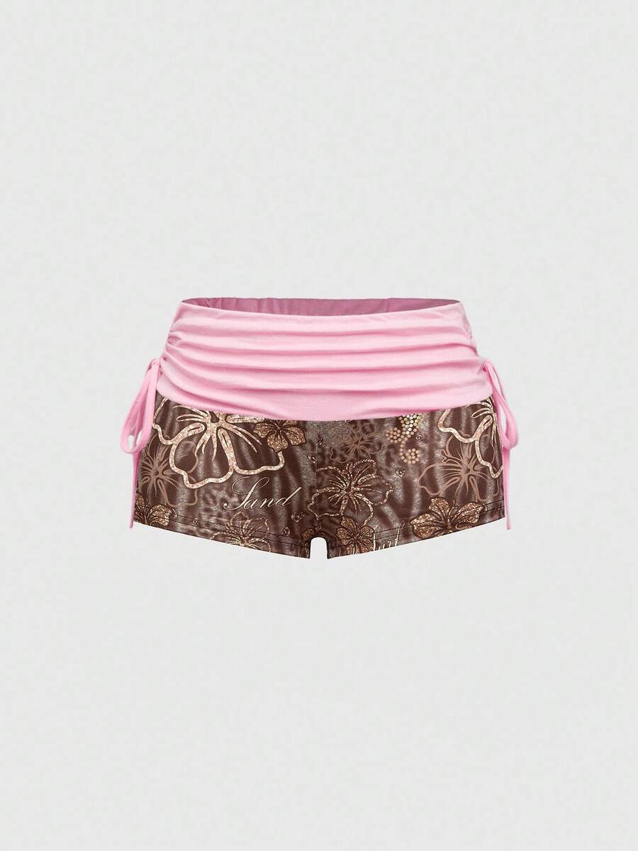 Women's low waist mini track shorts with elastic waistband, drawstring knot, ruched details, and plant pattern in a Y2K boho style