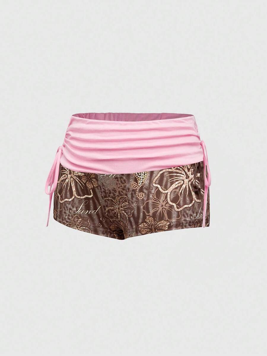 Women's low waist mini track shorts with elastic waistband, drawstring knot, ruched details, and plant pattern in a Y2K boho style