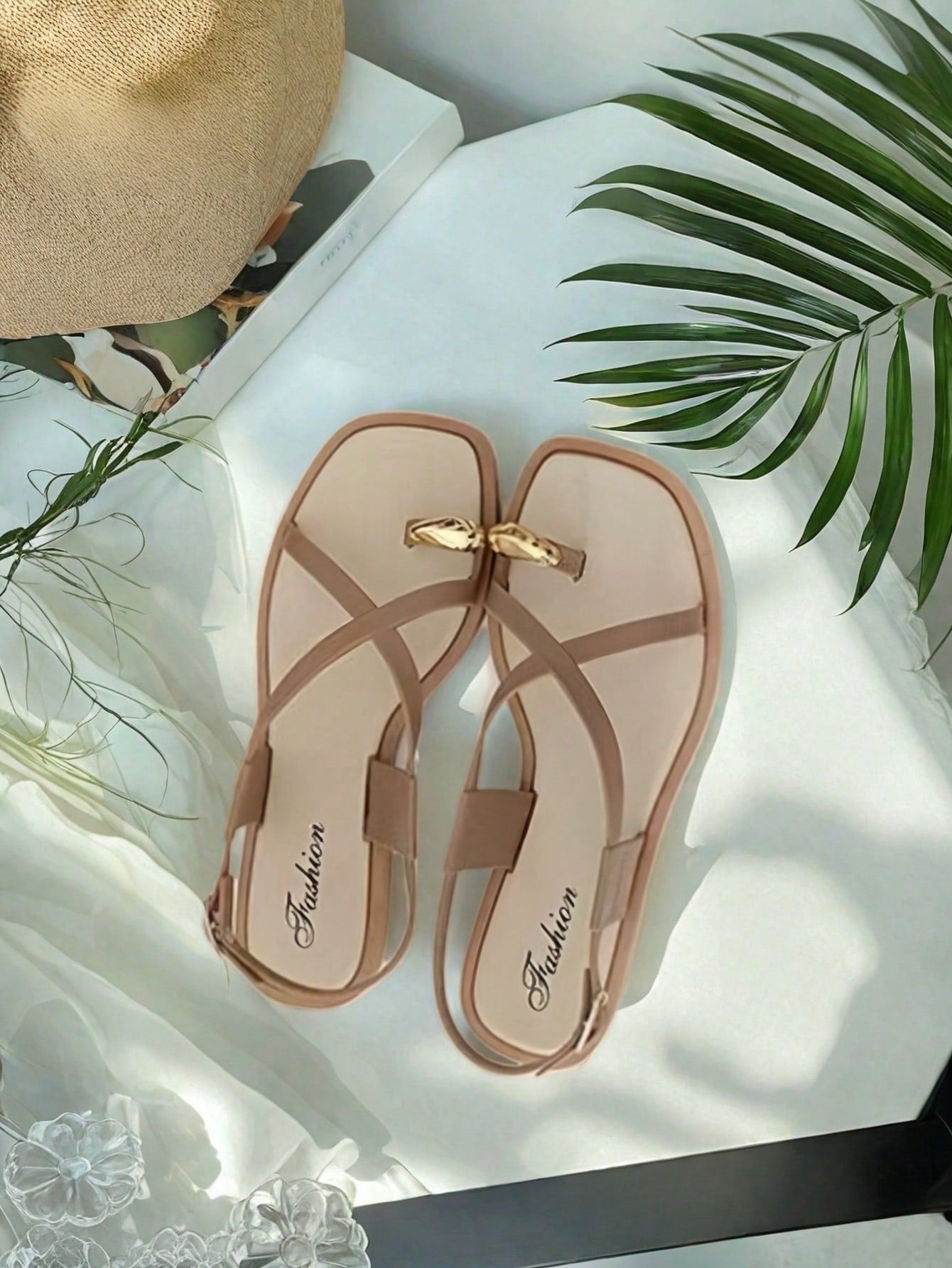 Women's white flat slide sandals featuring criss cross straps, shell detail, and buckle accents