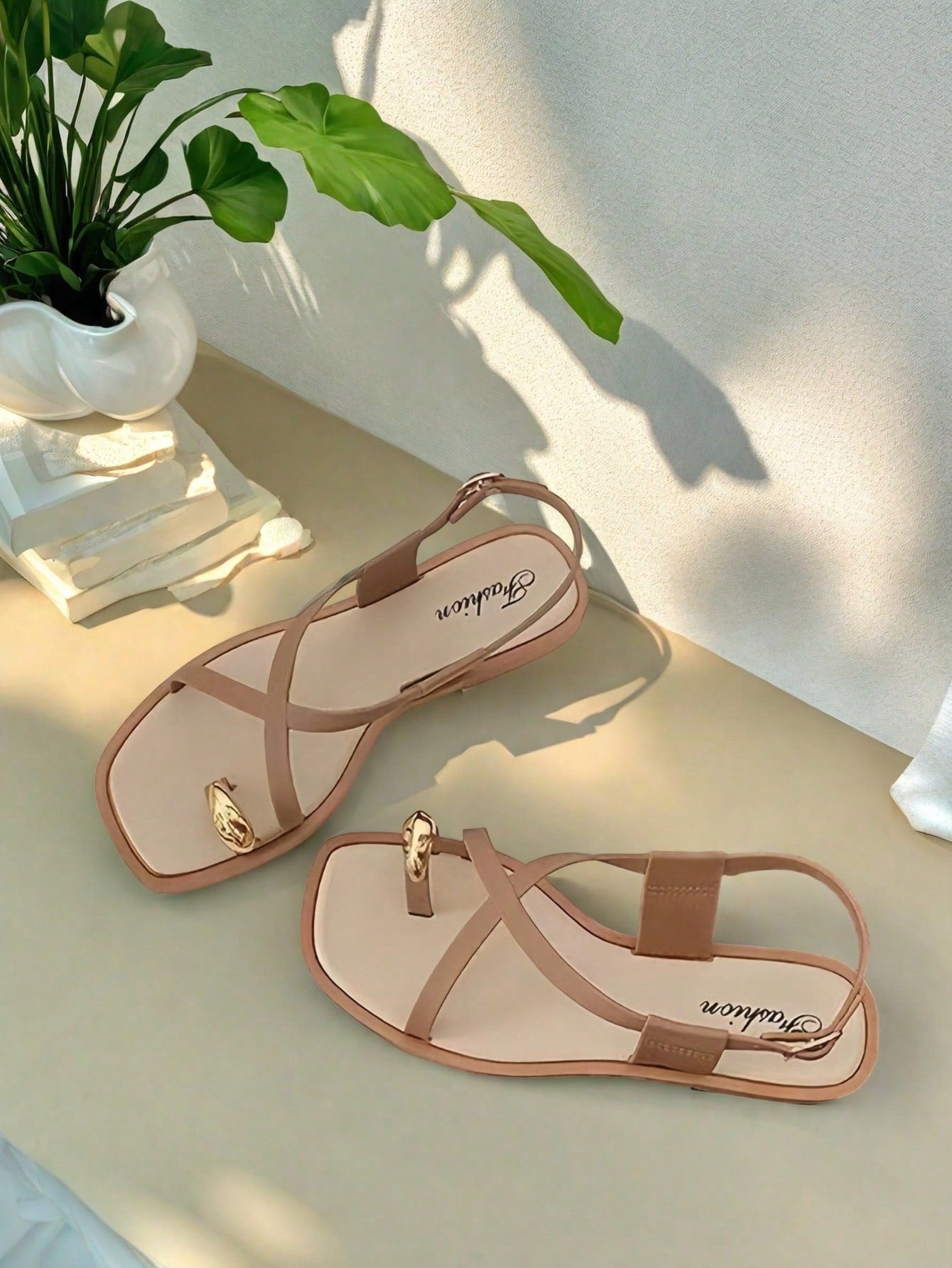 Women's white flat slide sandals featuring criss cross straps, shell detail, and buckle accents