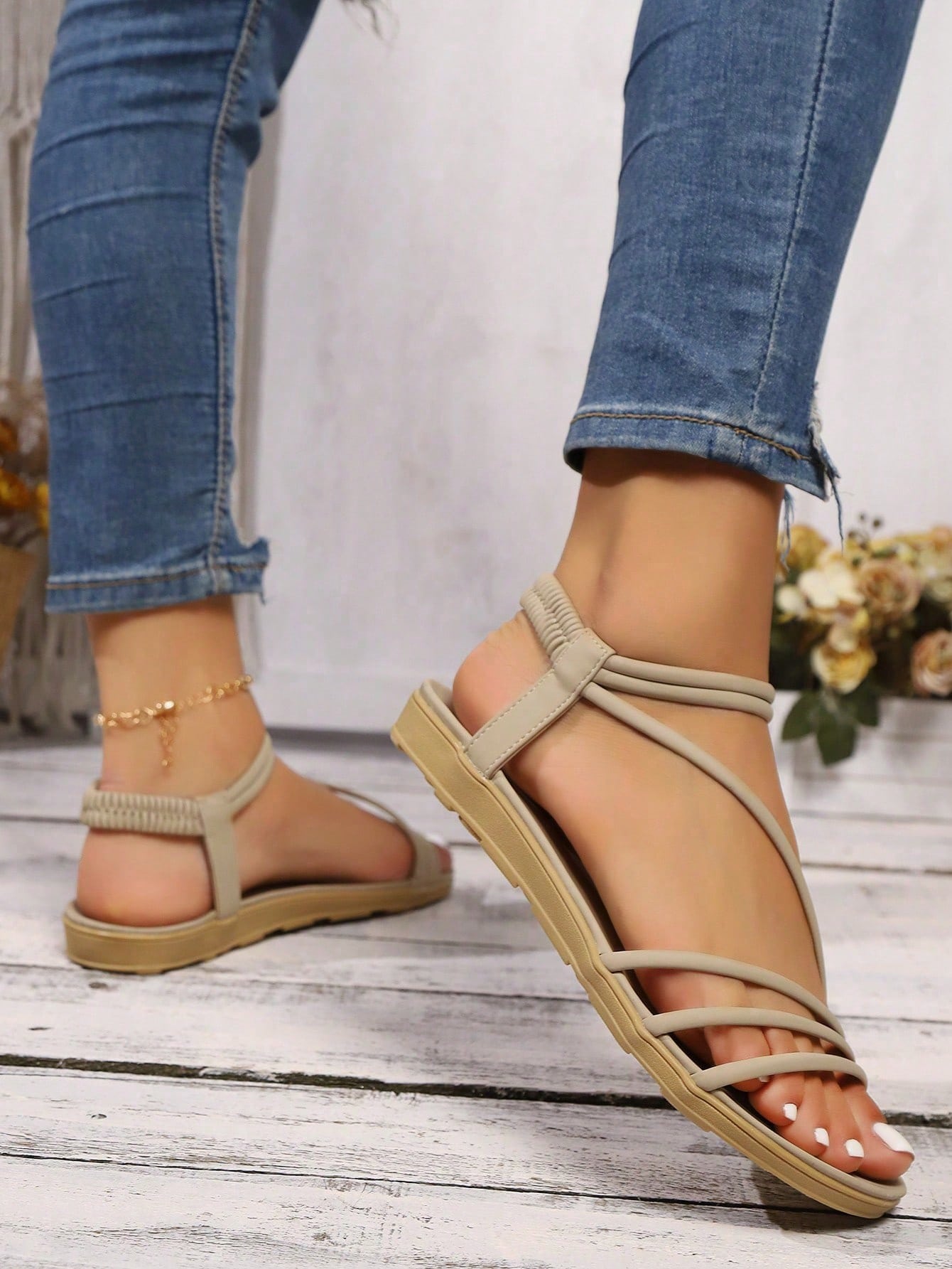Pair of women's elegant criss cross flat sandals with open toe design, ankle strap, and buckle detail in PU leather.