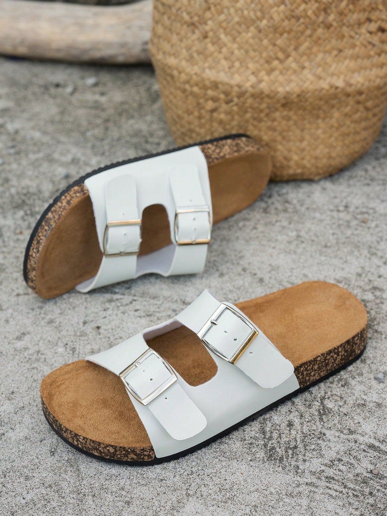 Classic white flat slide sandals with buckle detail and open-toe design.
