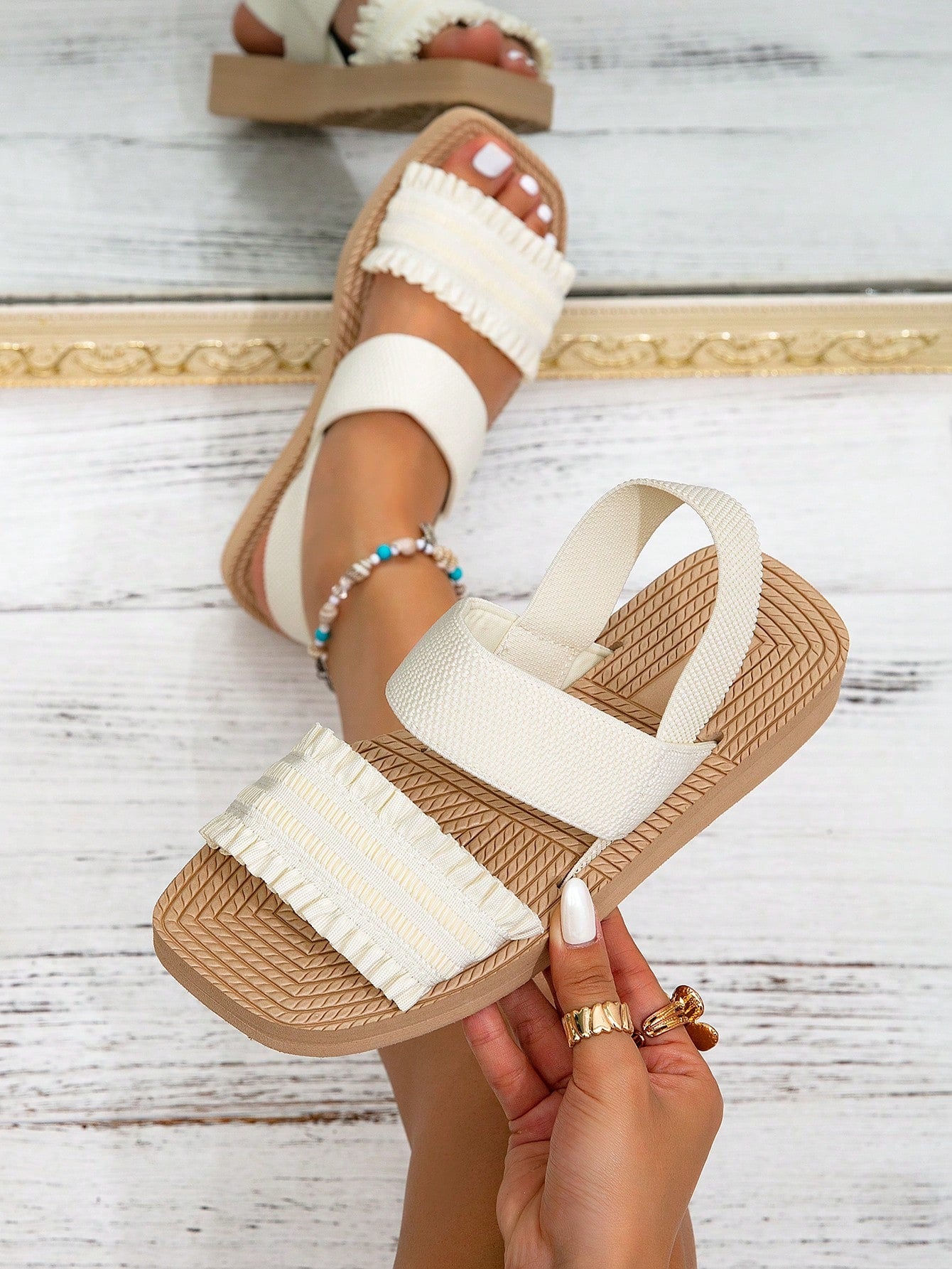 Women's black flat gladiator sandals with ruched and ruffle trim, textured fabric upper, and open-toe design for party, outdoor, and casual wear.