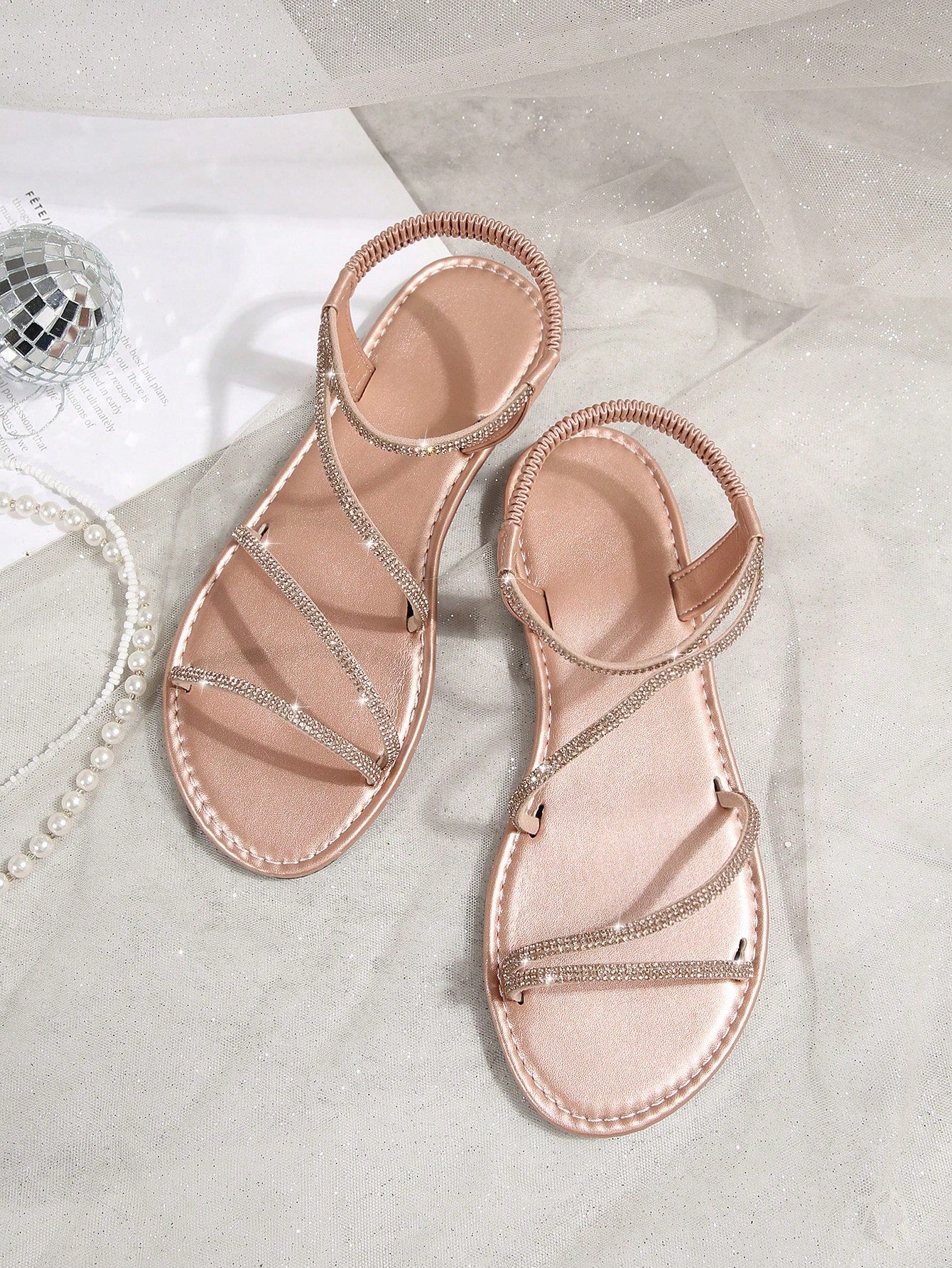 Women's flat sandals with rhinestone strap detail, elastic back, and open round toe in slide style for outdoor or beach wear.