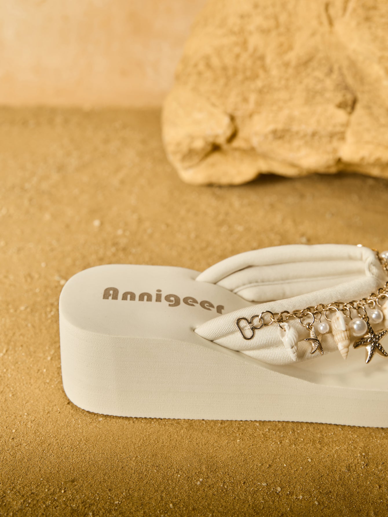 Beige women’s platform wedge slip-on sandals with toe post design, shell chain decoration, and plant pattern detail.