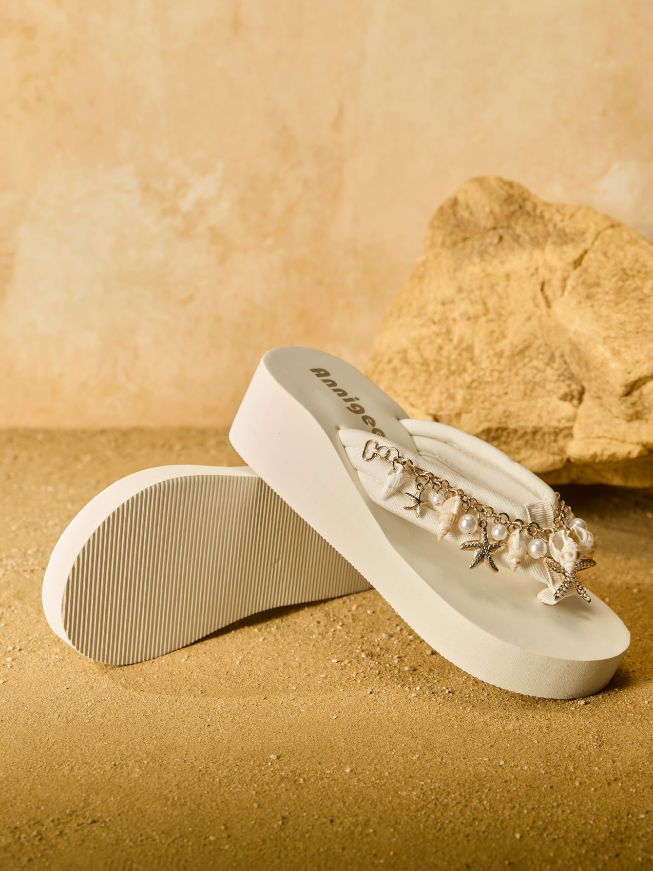 Beige women’s platform wedge slip-on sandals with toe post design, shell chain decoration, and plant pattern detail.