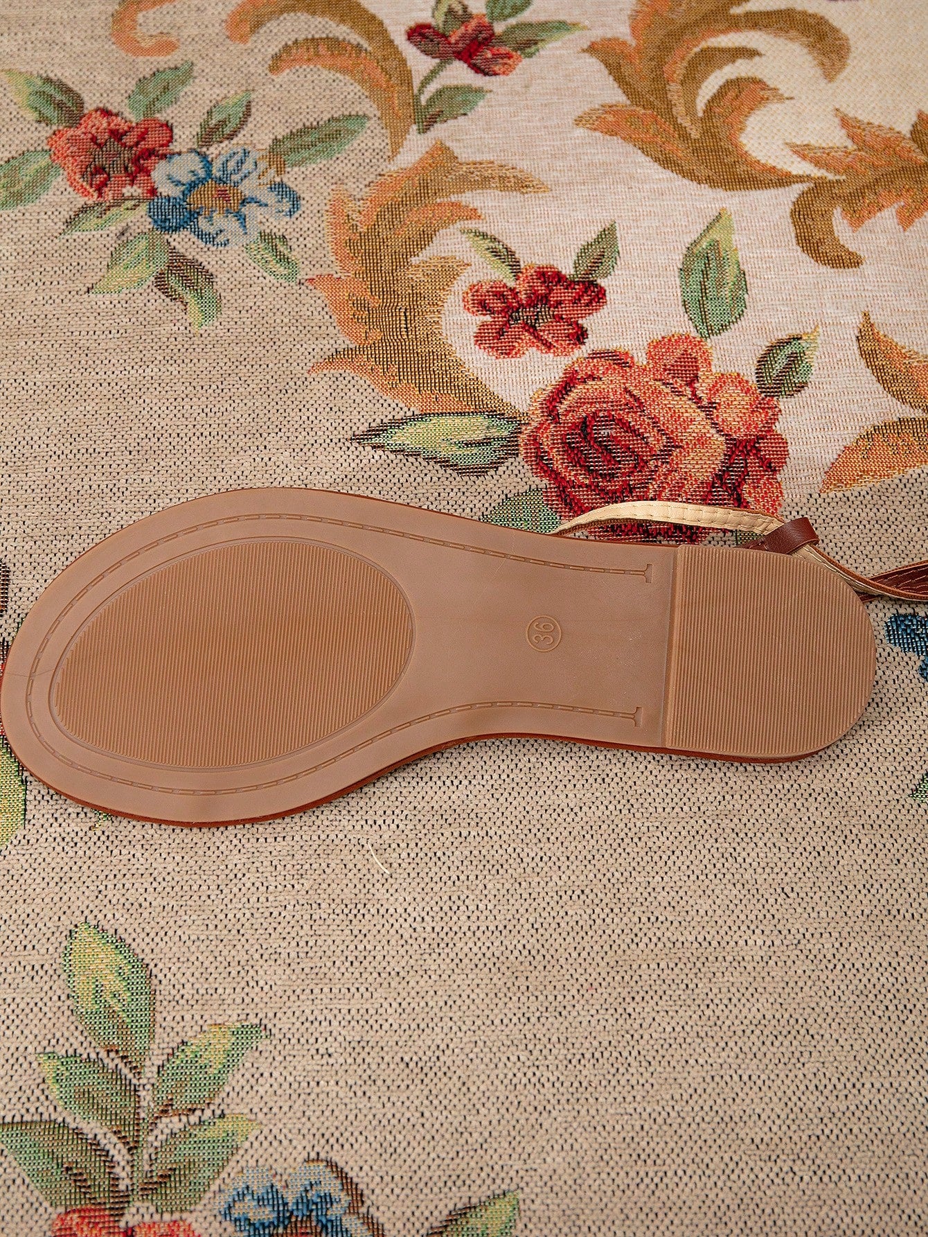 Pair of women’s gold flat sandals featuring a toe ring thong toe post design, criss-cross straps, and a slingback ankle strap.