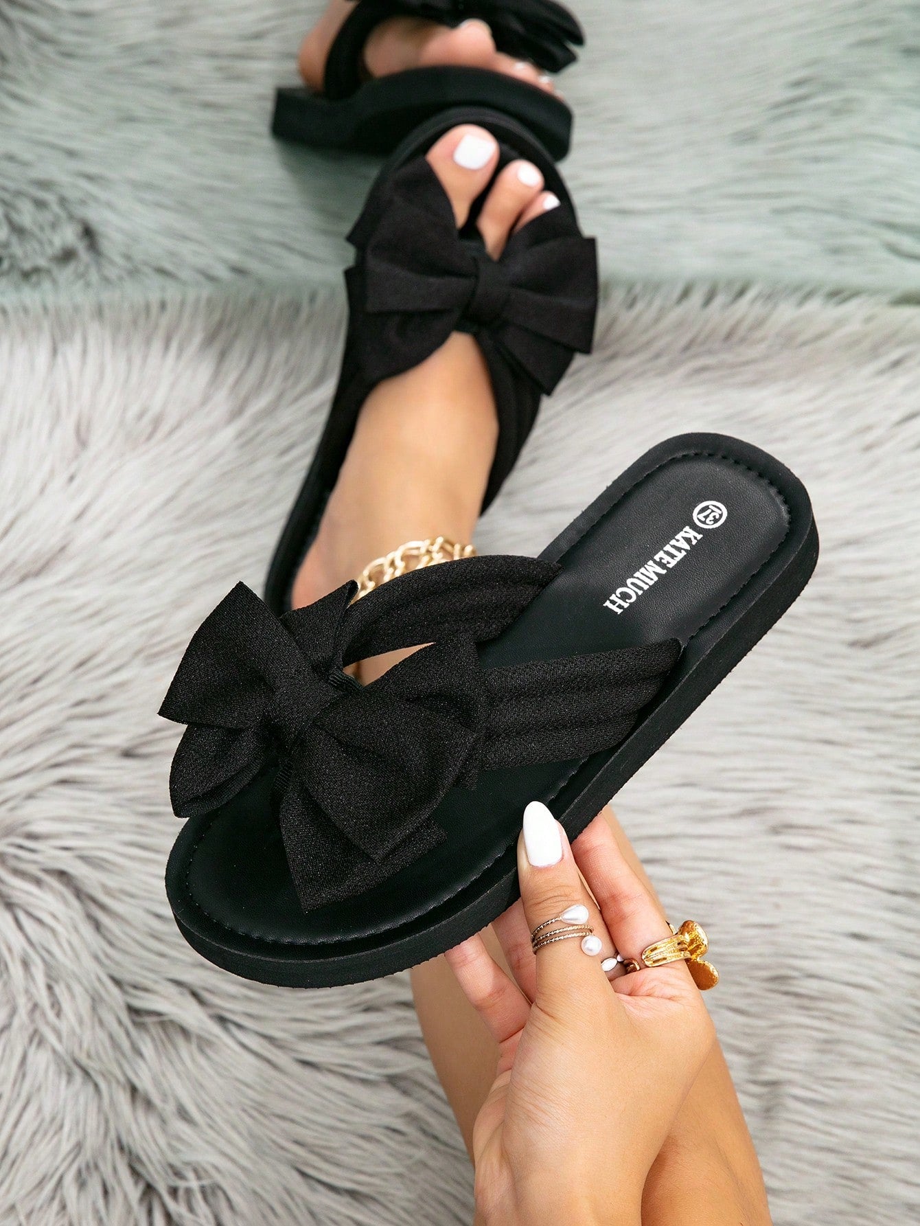 Women's flat slide sandals with ruched fabric, bow accent, and fringe detail, suitable for outdoor vacation wear.