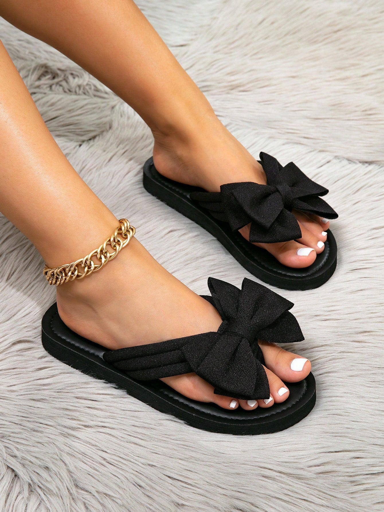 Women's flat slide sandals with ruched fabric, bow accent, and fringe detail, suitable for outdoor vacation wear.