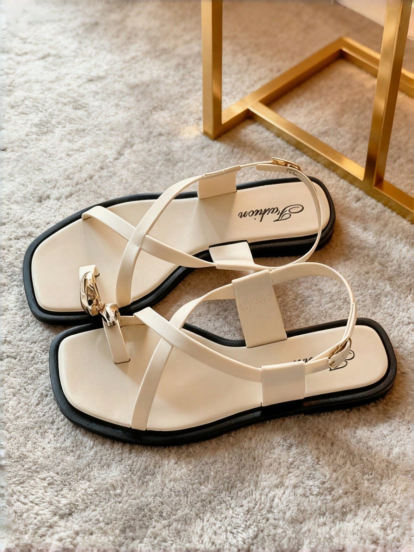 Women's white flat slide sandals featuring criss cross straps, shell detail, and buckle accents