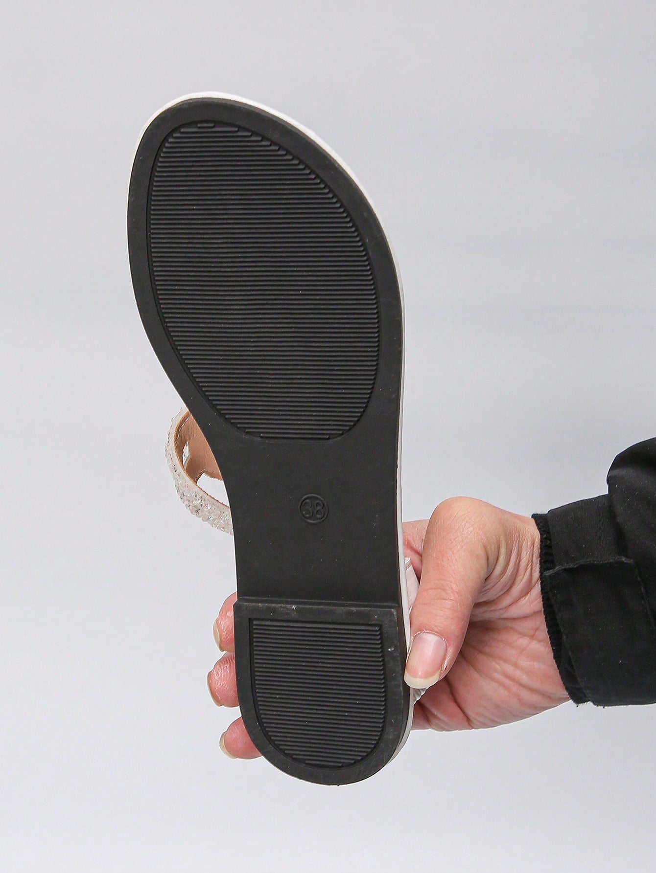 Women’s plus size 35-45 flat thong sandals with elastic strap, round toe shape, textured pattern, and rhinestone asymmetrical detail in slip-on beach style for outdoor summer wear.