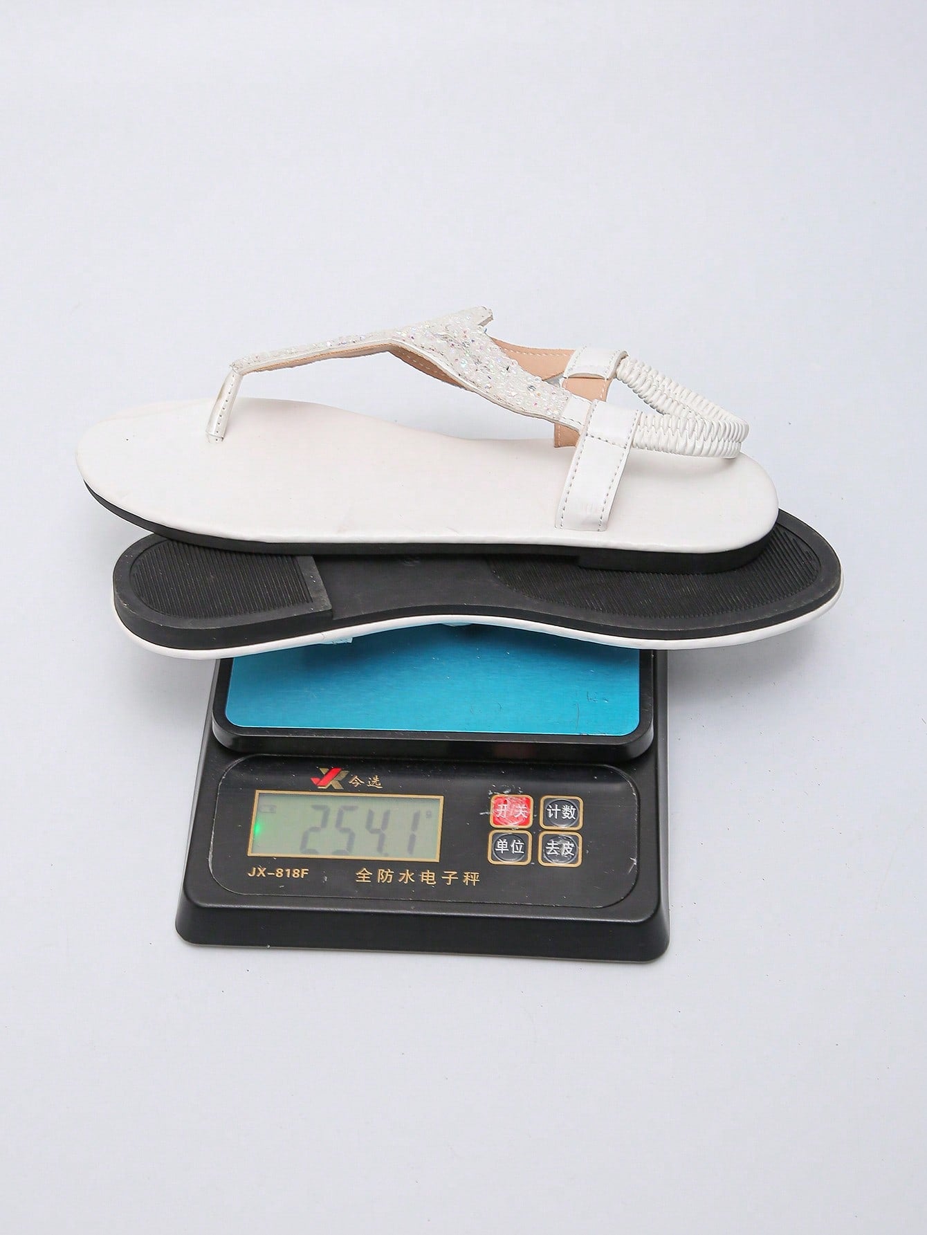 Women’s plus size 35-45 flat thong sandals with elastic strap, round toe shape, textured pattern, and rhinestone asymmetrical detail in slip-on beach style for outdoor summer wear.