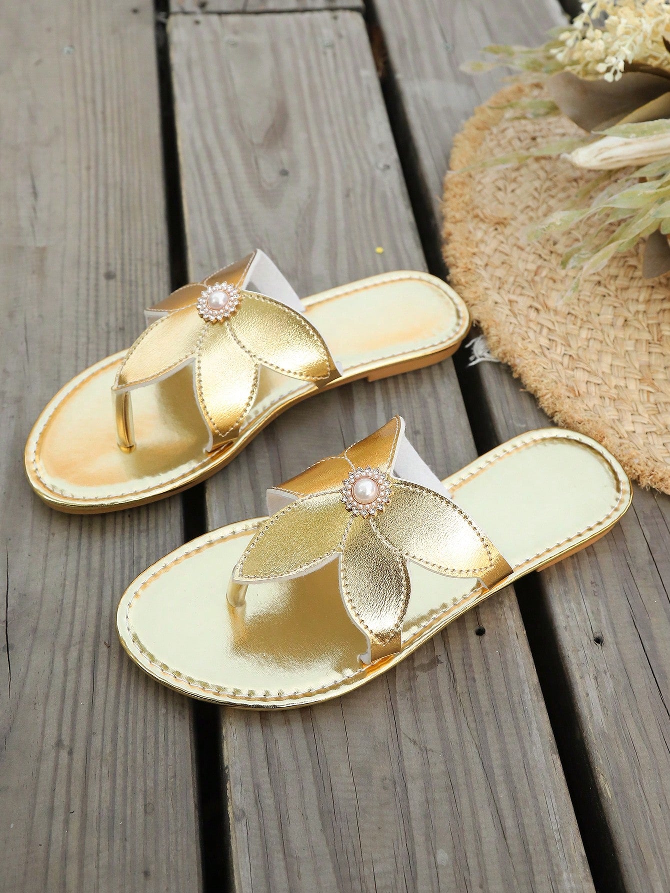 Women’s gold flat slide sandals with open toe post design and metal buckle detail, shown as fashionable outdoor summer footwear.