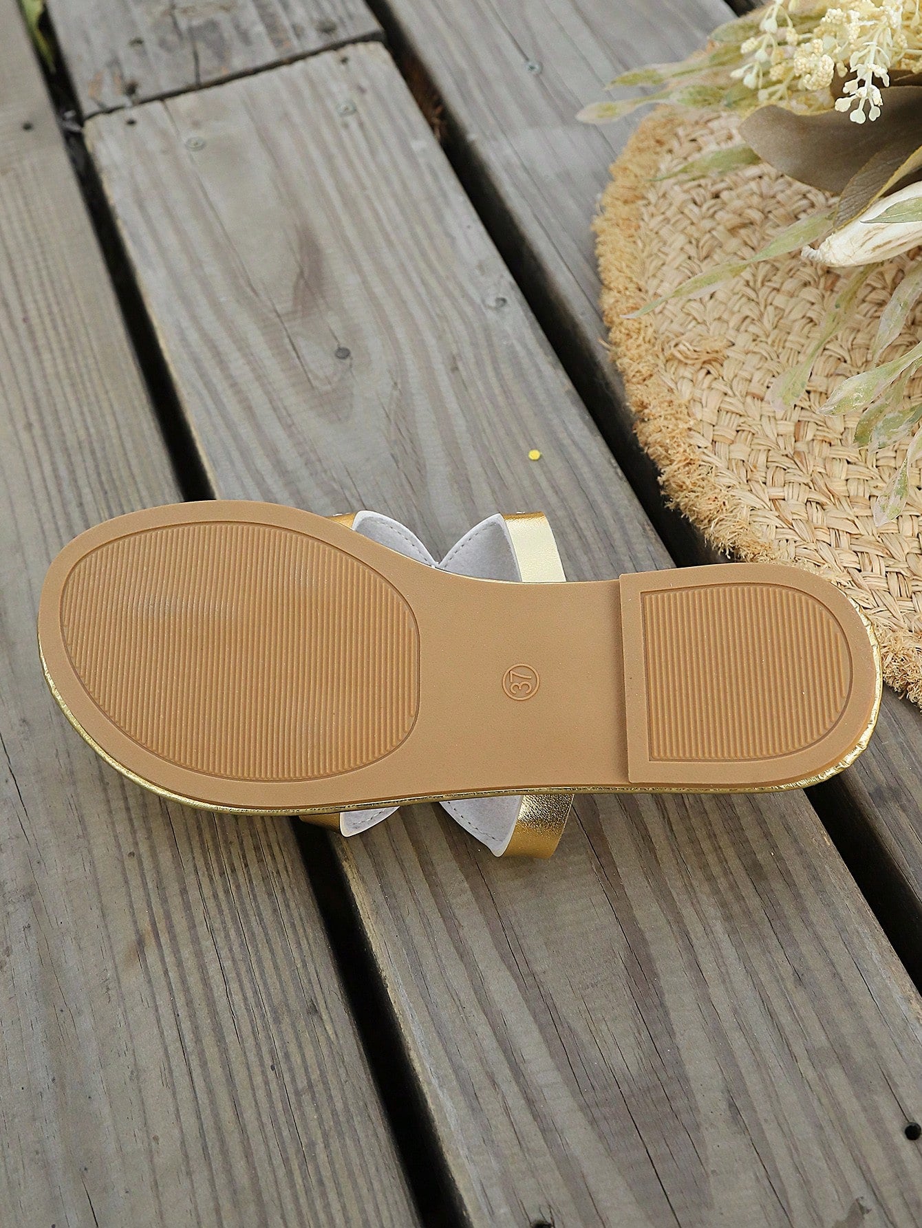 Women’s gold flat slide sandals with open toe post design and metal buckle detail, shown as fashionable outdoor summer footwear.