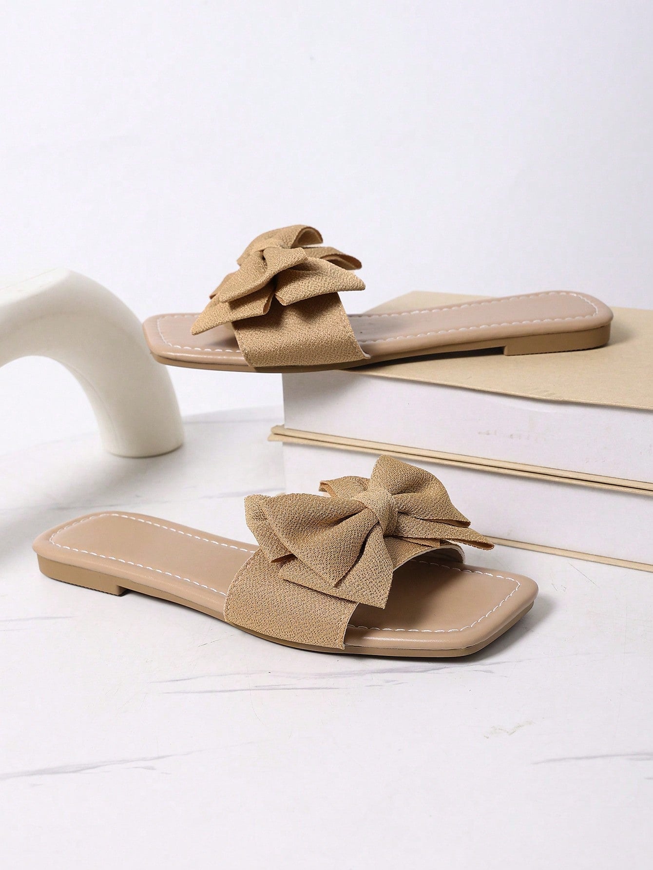 Women's khaki flat slide sandals with open toe, bow tie detail, and floral plant-pattern vacation style design.