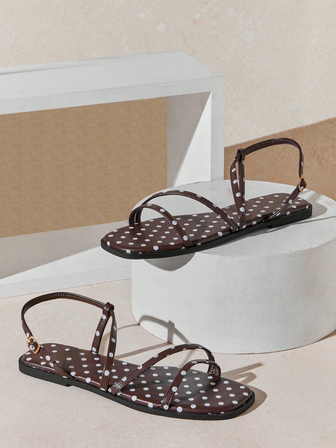 Women's flat open-toe sandals featuring a buckle detail and PU leather construction with a flat sole.