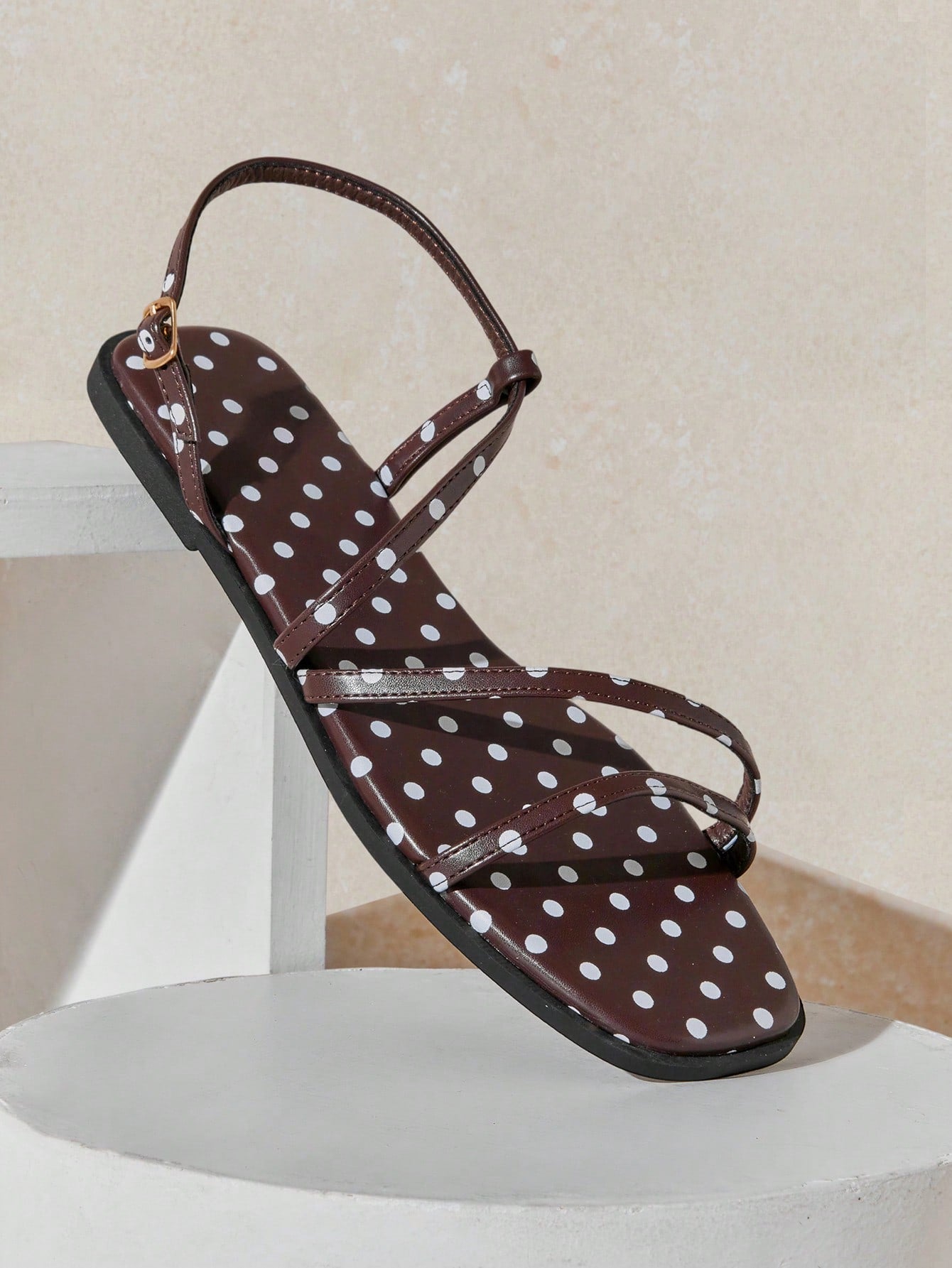 Women's flat open-toe sandals featuring a buckle detail and PU leather construction with a flat sole.