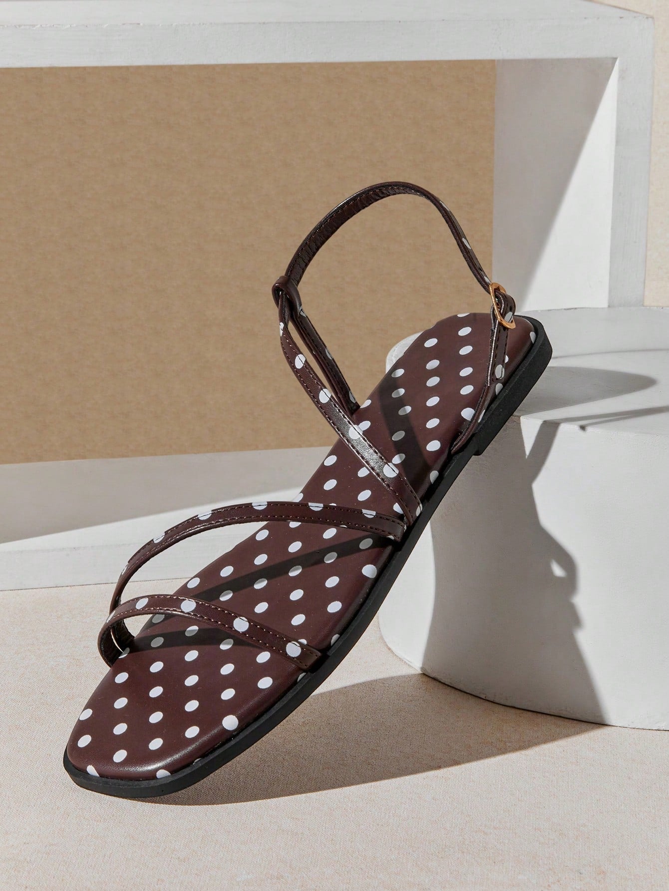 Women's flat open-toe sandals featuring a buckle detail and PU leather construction with a flat sole.