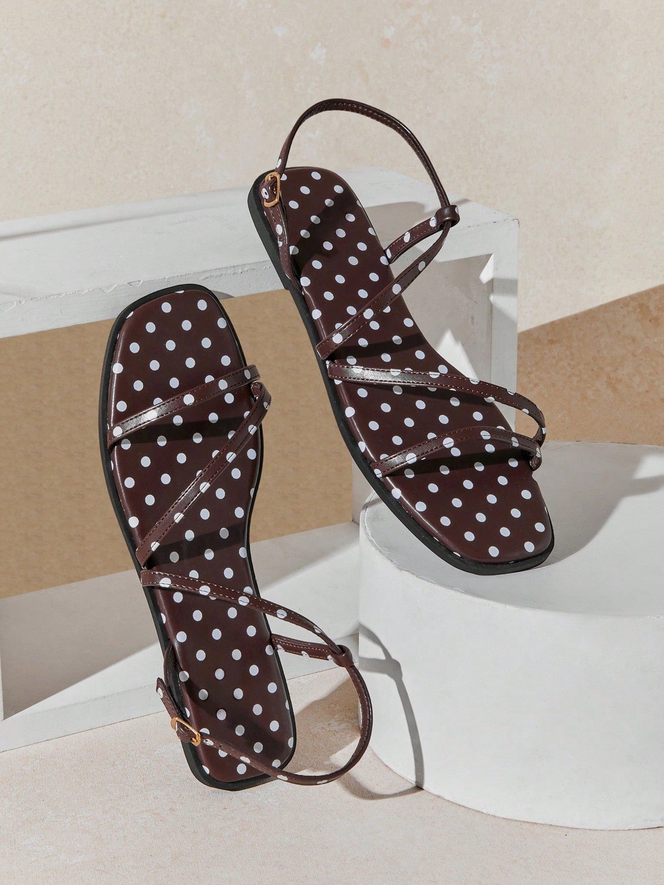Women's flat open-toe sandals featuring a buckle detail and PU leather construction with a flat sole.