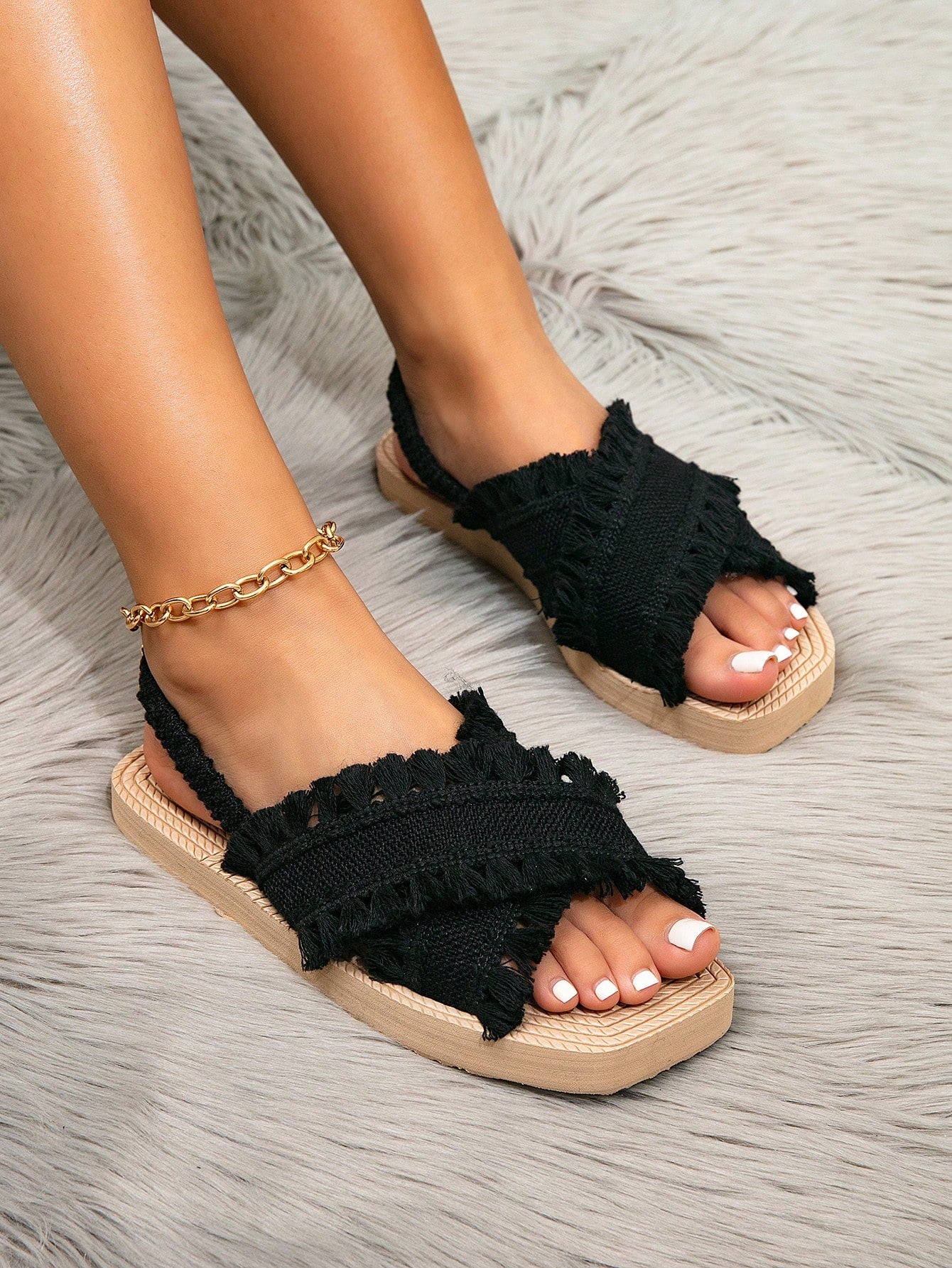 Women's white open-toe flat slide sandals featuring ruched fabric, bow accent, and fringe detail in a minimalist retro style.