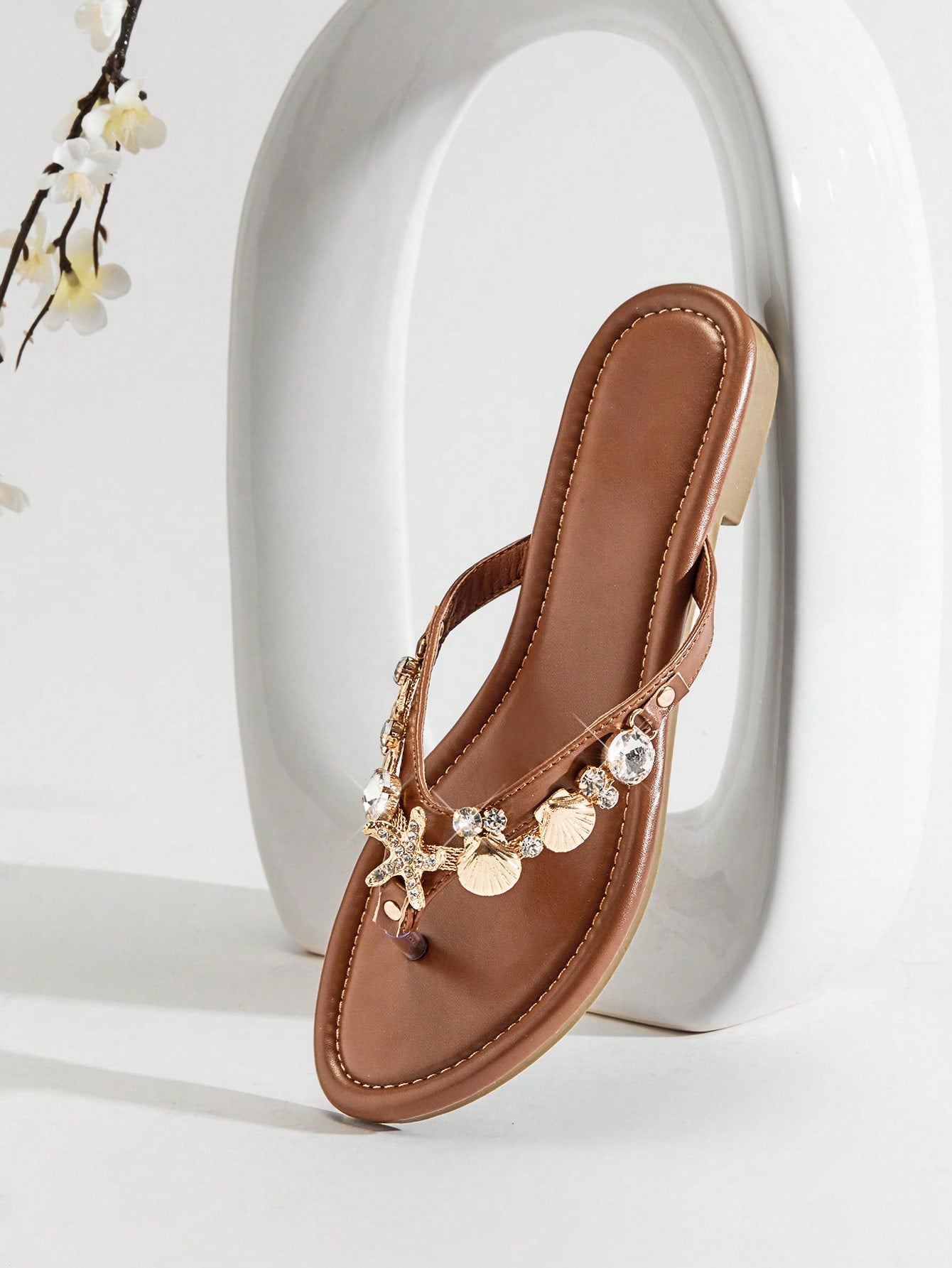 Women's flat toe post thong sandals with sea shell and starfish decoration, slide-style design, PU leather upper and TPR outsole.