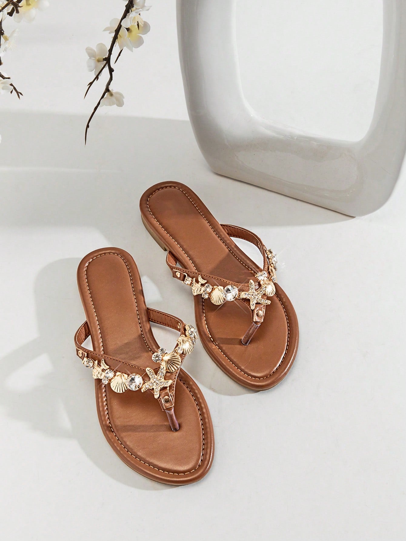 Women's flat toe post thong sandals with sea shell and starfish decoration, slide-style design, PU leather upper and TPR outsole.