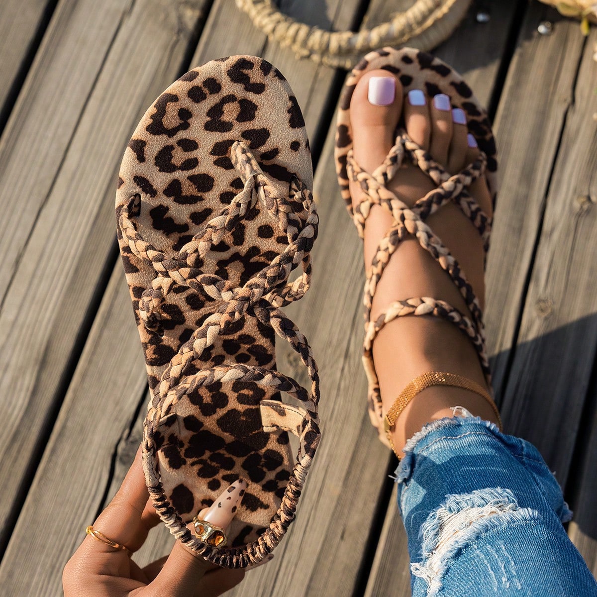 Women’s leopard print woven strap Roman-style flat slide sandals with toe post and cut-out detail.