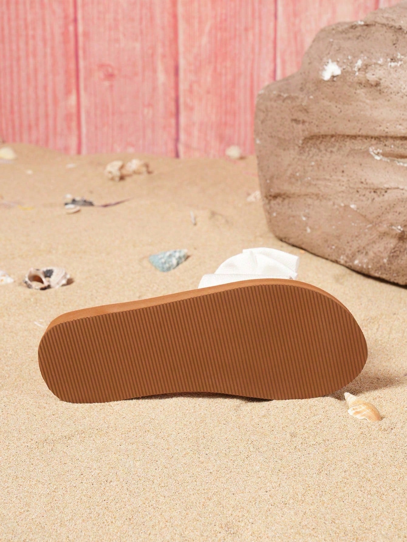 Brown vintage chic flip flops with metal shell decor, toe-post slide design, criss cross straps, and wedge sole for casual beach and outdoor wear.